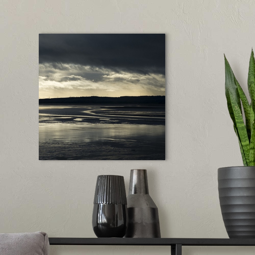 A modern room featuring A photograph of a watery landscape under dark clouds.
