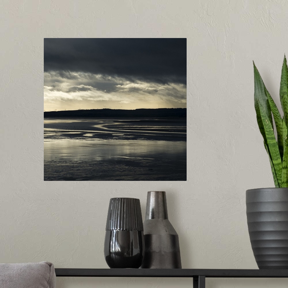A modern room featuring A photograph of a watery landscape under dark clouds.