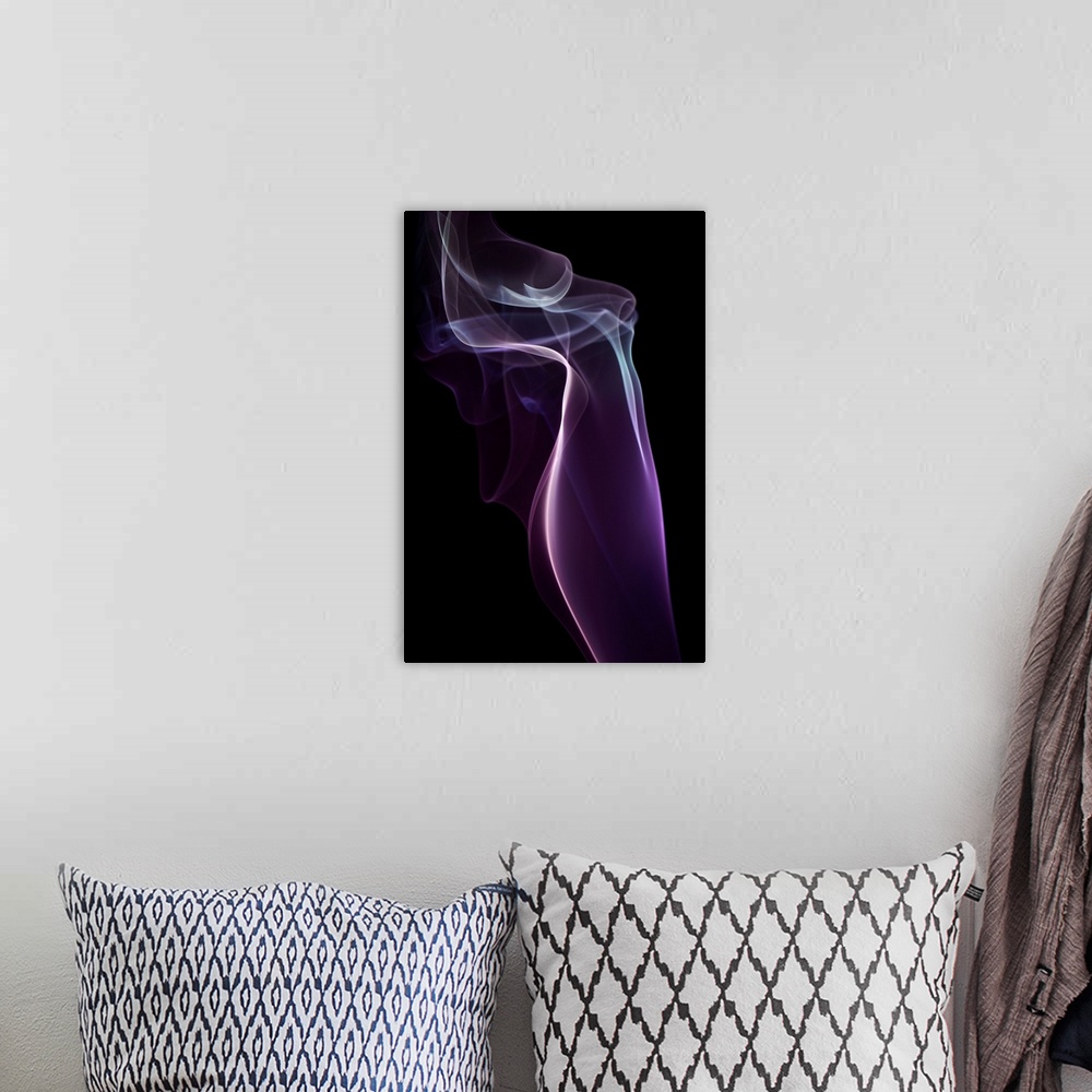 A bohemian room featuring A photograph of colorful sinuous smoke against a black background.