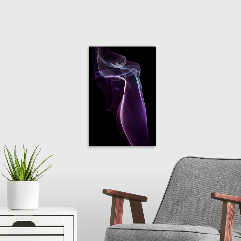 A modern room featuring A photograph of colorful sinuous smoke against a black background.