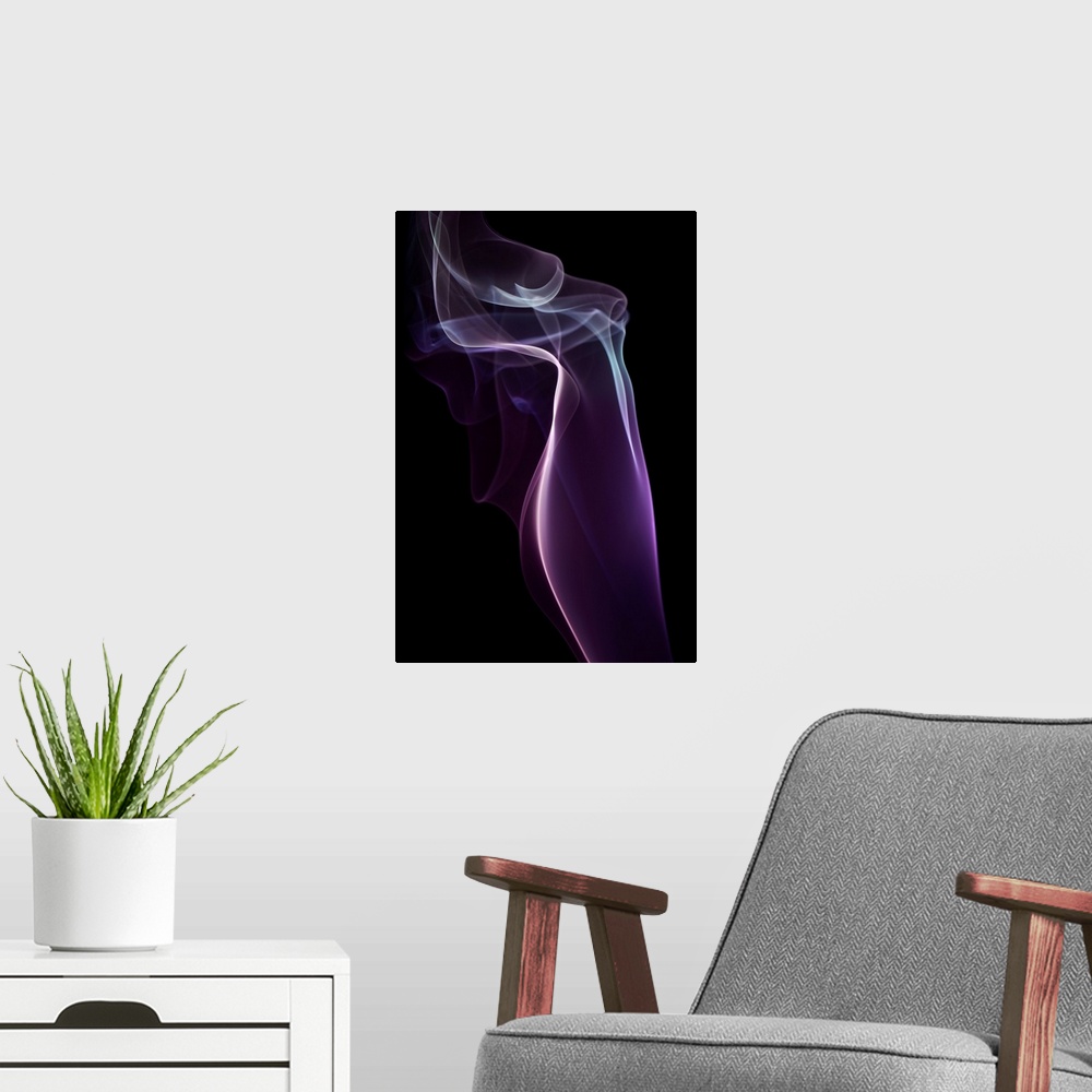 A modern room featuring A photograph of colorful sinuous smoke against a black background.