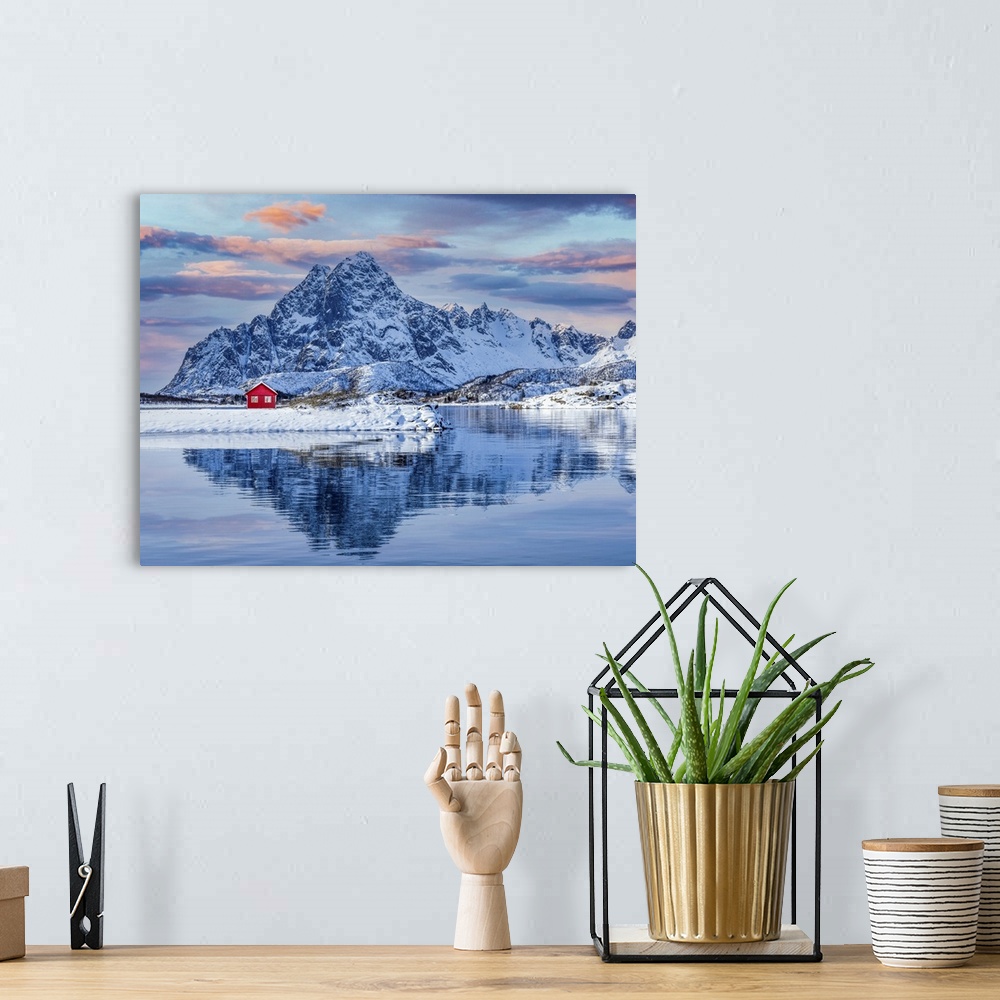 A bohemian room featuring The Lofoten Islands offer spectacular scenery, a red house and the imposing snow-capped mountain ...