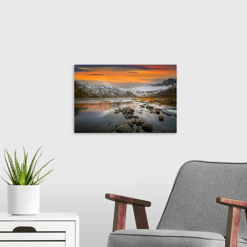 A modern room featuring Snowy mountains in Lofoten, Norway, by a glacial lake at sunset.