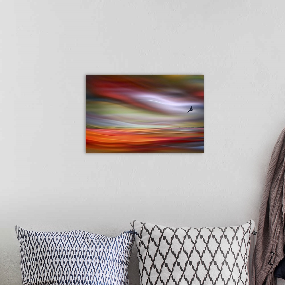 A bohemian room featuring An abstract photograph of a bird silhouette against a wavy colorful sky.