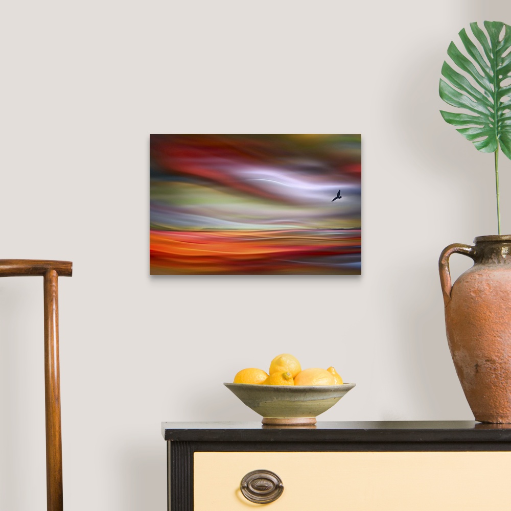 A traditional room featuring An abstract photograph of a bird silhouette against a wavy colorful sky.