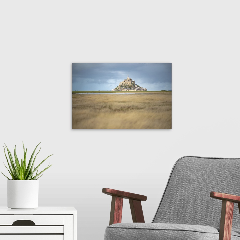 A modern room featuring Mont Saint Michel in France in the middle of the meandres under a blue sky.
