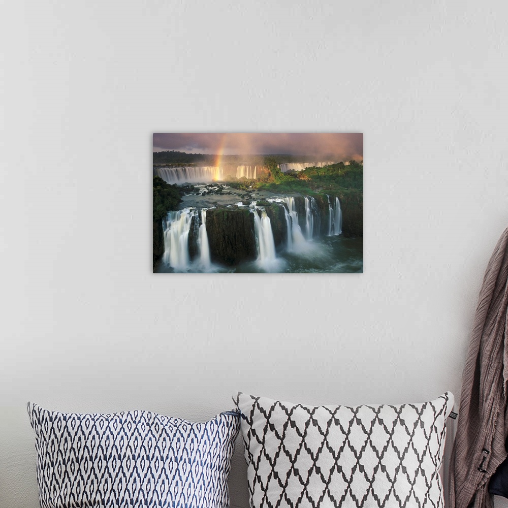 A bohemian room featuring Big, horizontal, wide angle photograph of Iguazu Falls with a rainbow descending into the waters.