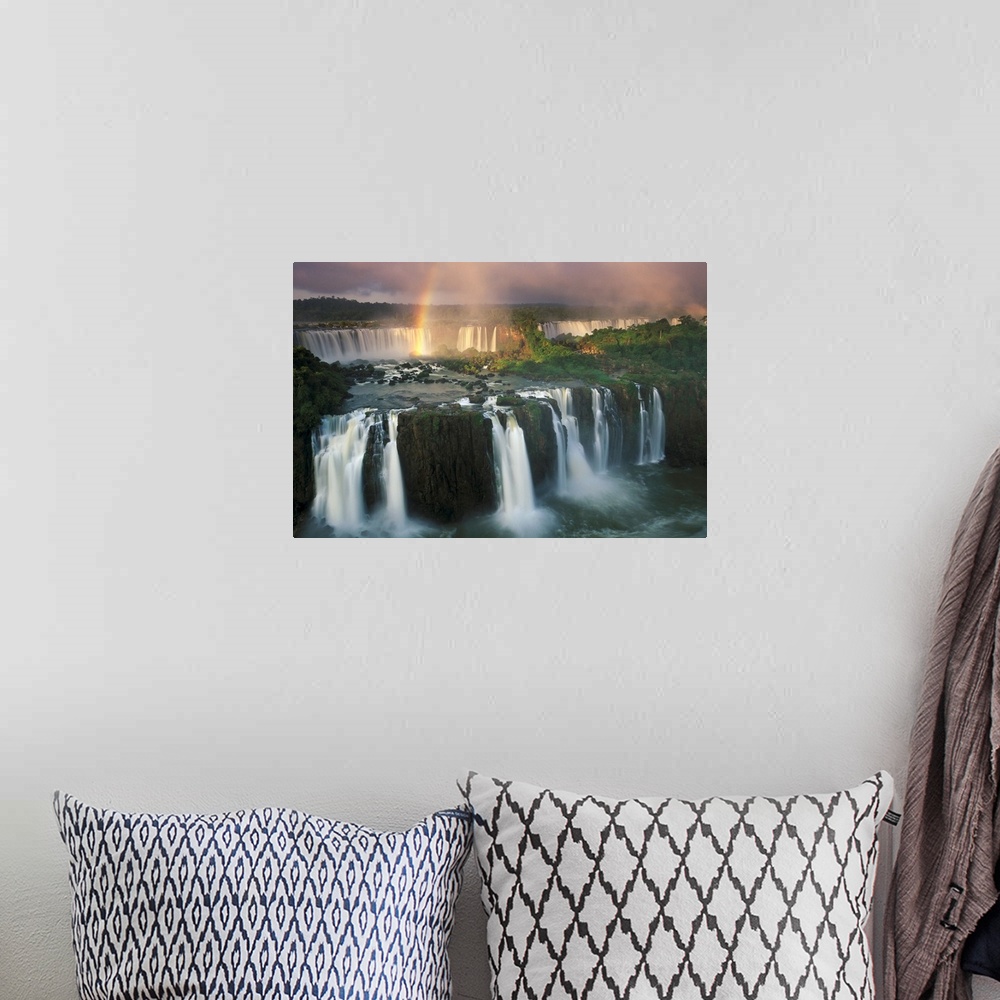 A bohemian room featuring Big, horizontal, wide angle photograph of Iguazu Falls with a rainbow descending into the waters.