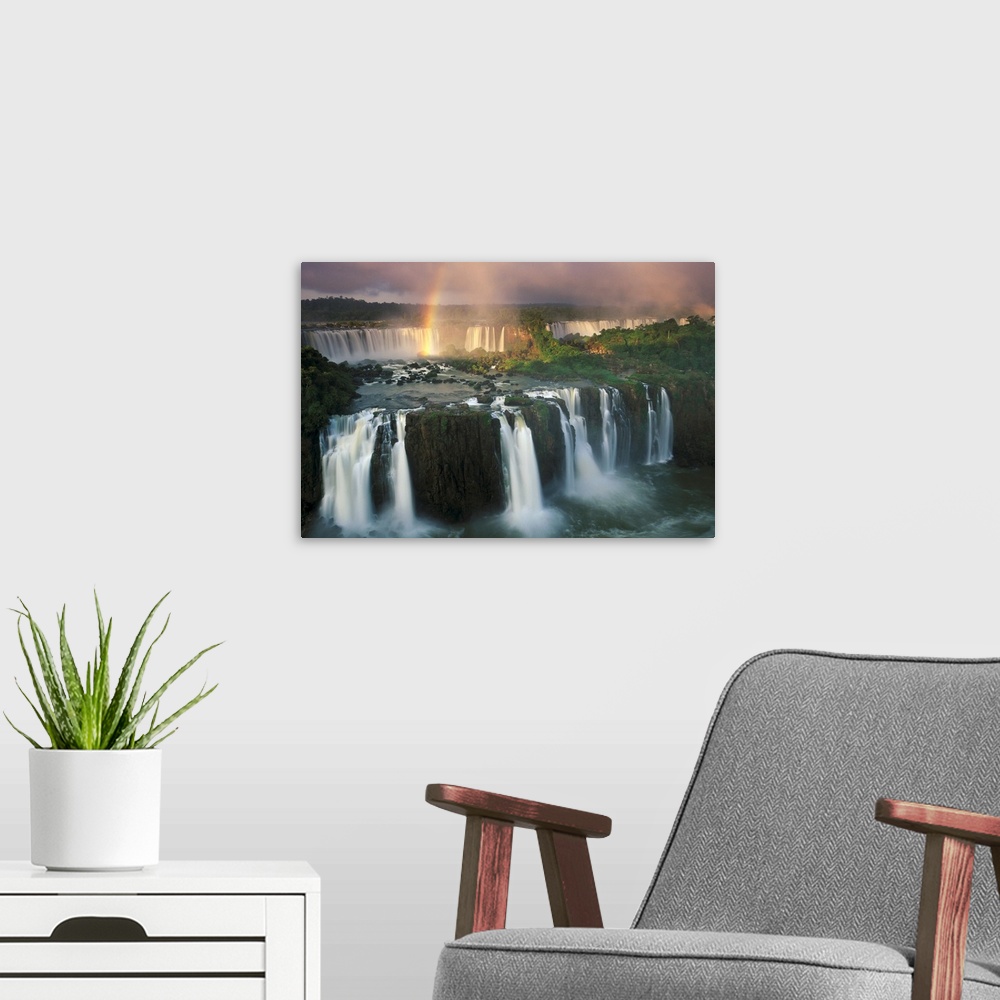 A modern room featuring Big, horizontal, wide angle photograph of Iguazu Falls with a rainbow descending into the waters.