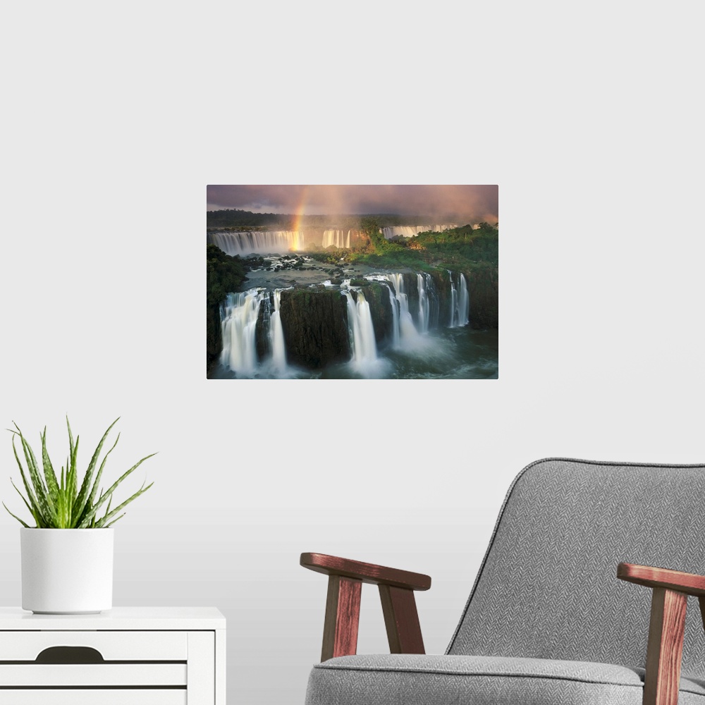 A modern room featuring Big, horizontal, wide angle photograph of Iguazu Falls with a rainbow descending into the waters.