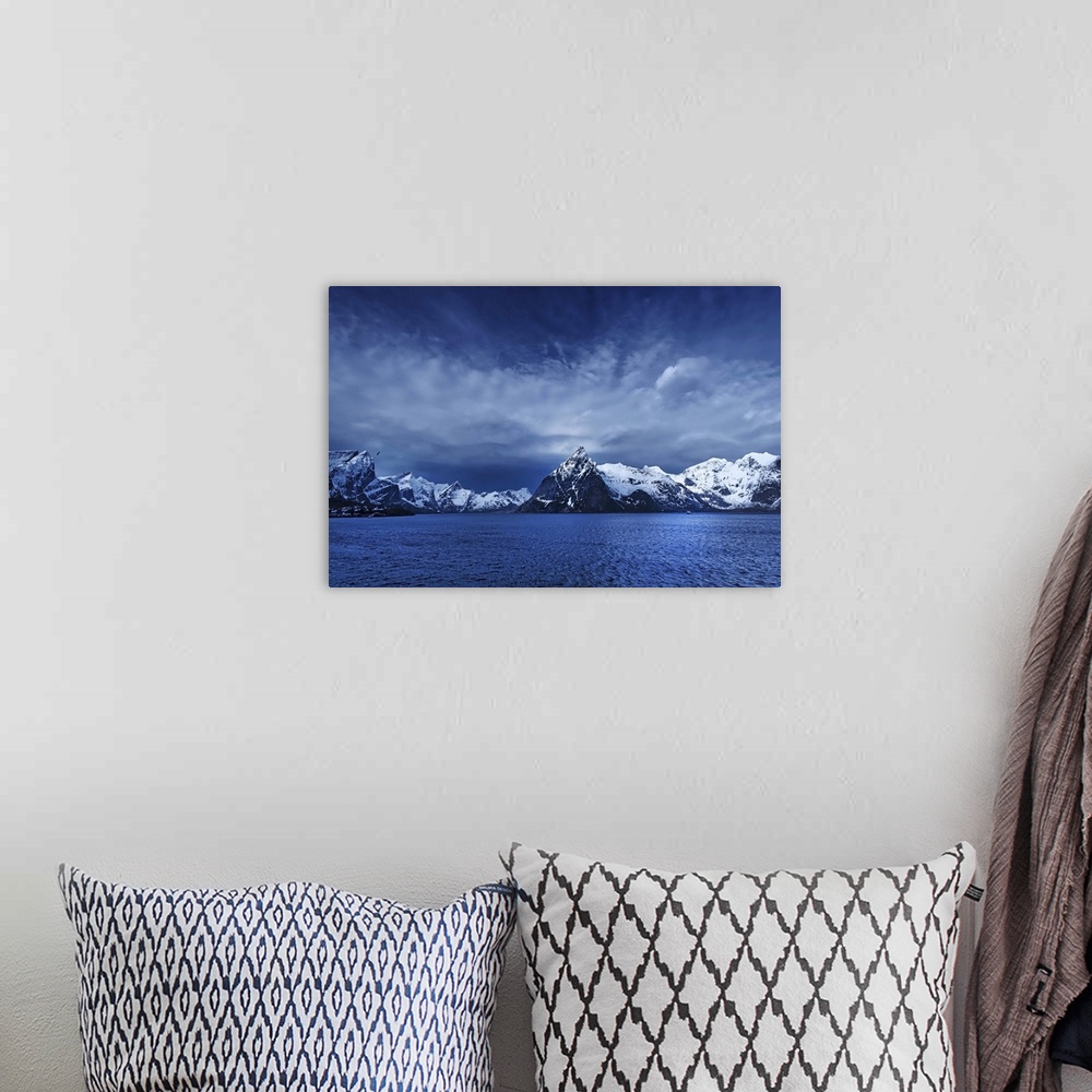 A bohemian room featuring A photograph of a mountain range seen from across a lake in winter.