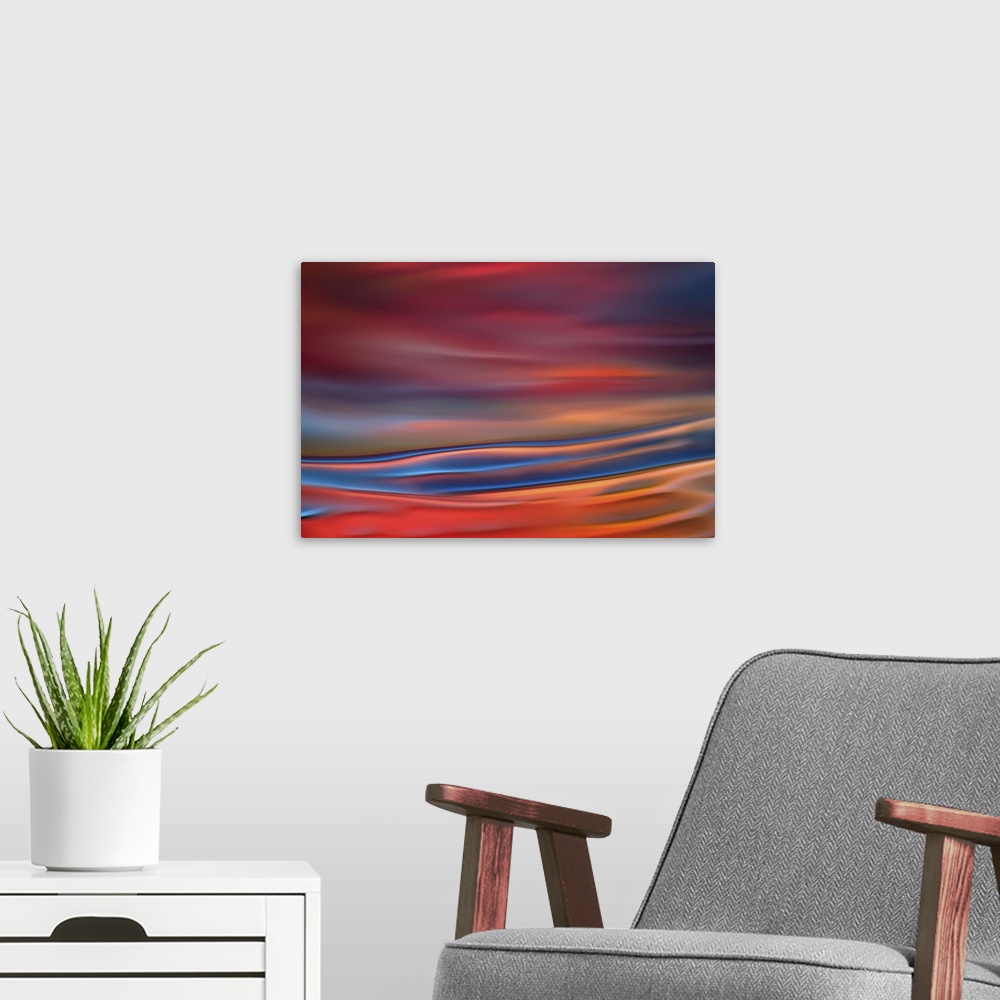 A modern room featuring Abstract photograph in blue and red shades resembling ocean waves.