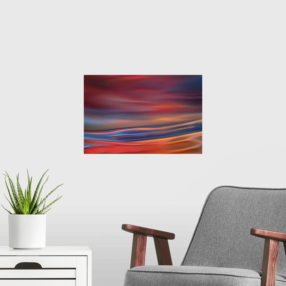 A modern room featuring Abstract photograph in blue and red shades resembling ocean waves.
