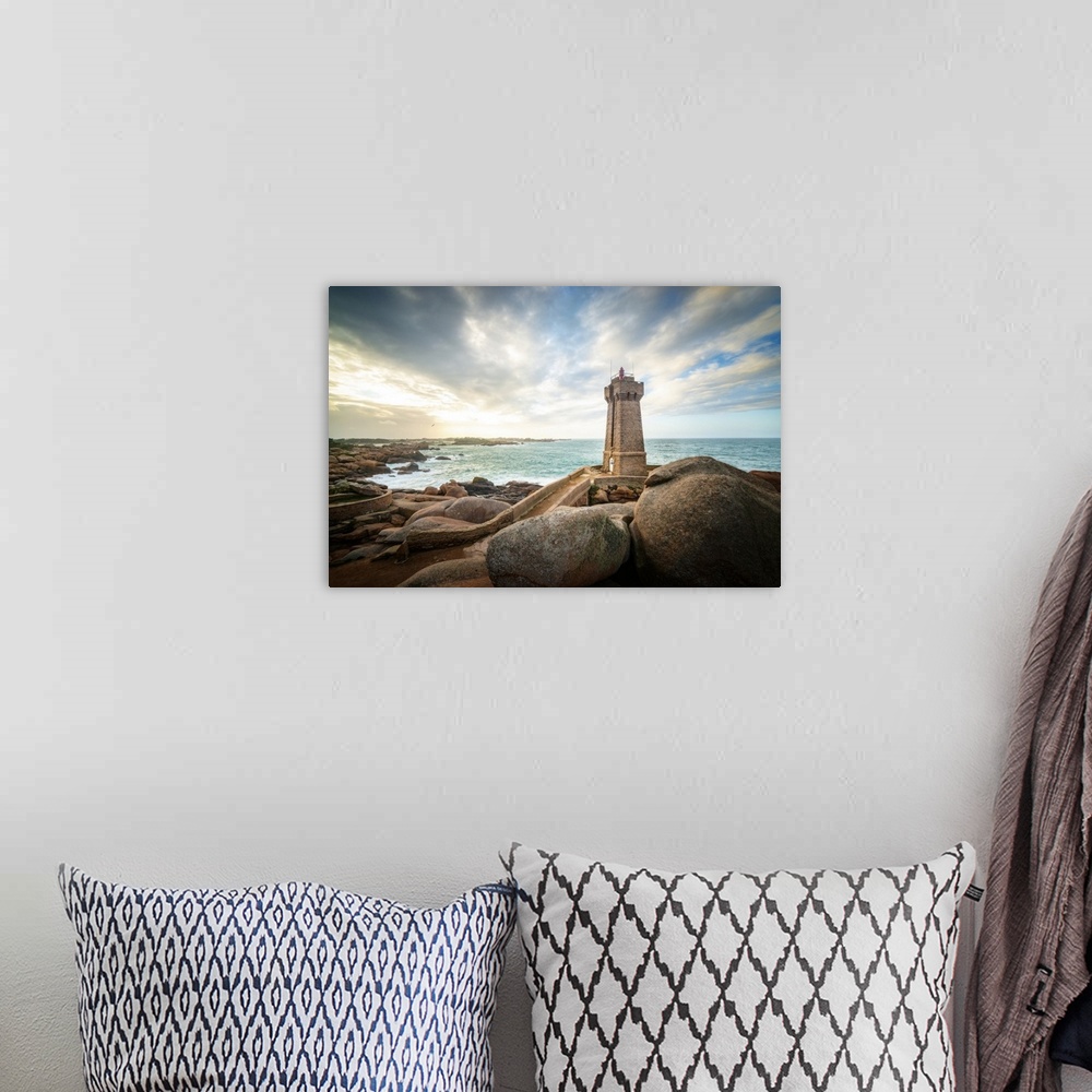 A bohemian room featuring Men Ruz lighthouse in Brittany in France on pink granit coast under a lighthing sky.