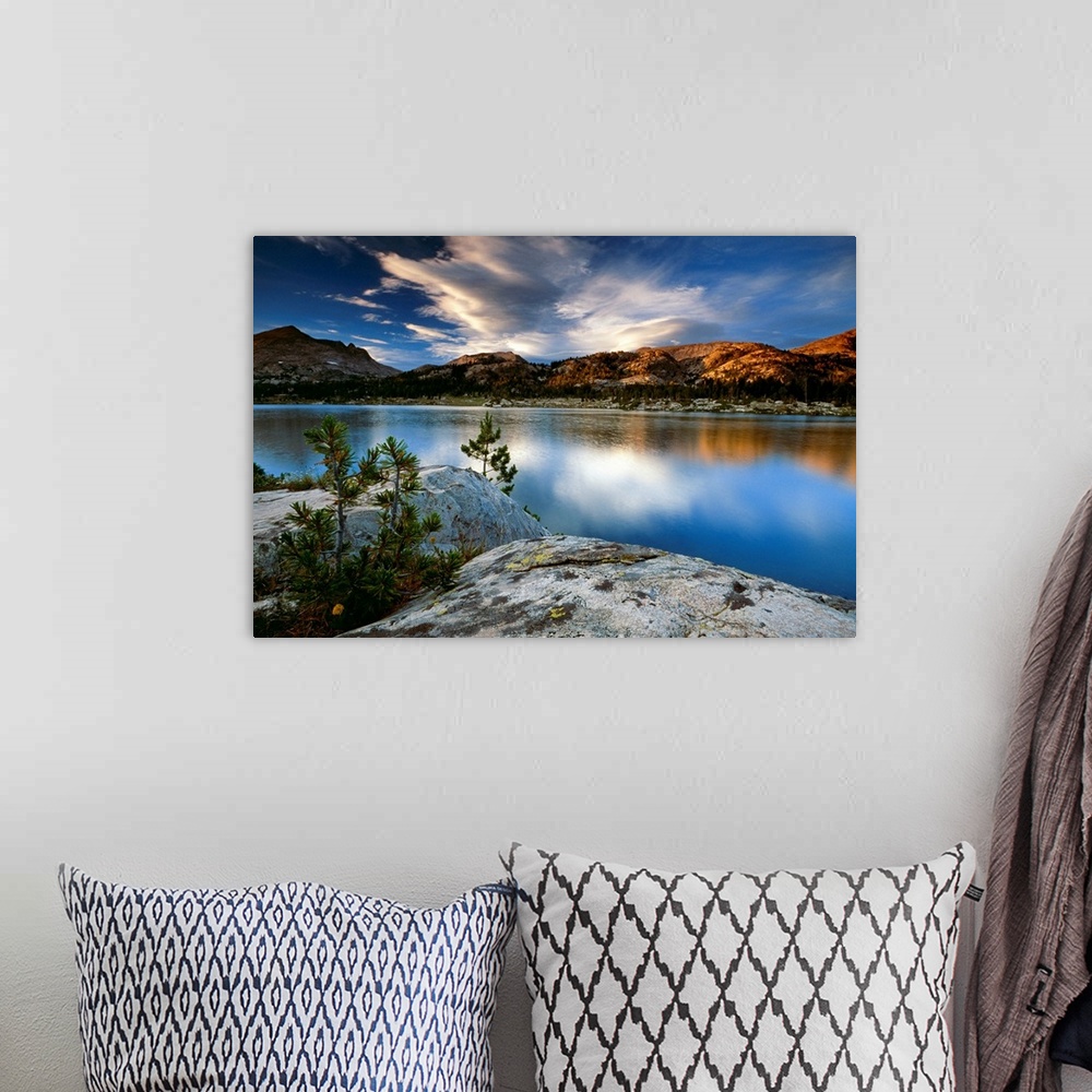 A bohemian room featuring Clouds and mountains reflect in the surface of the still water in this oversized art for the deco...
