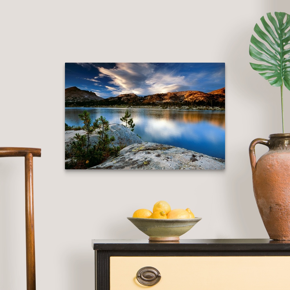 A traditional room featuring Clouds and mountains reflect in the surface of the still water in this oversized art for the deco...