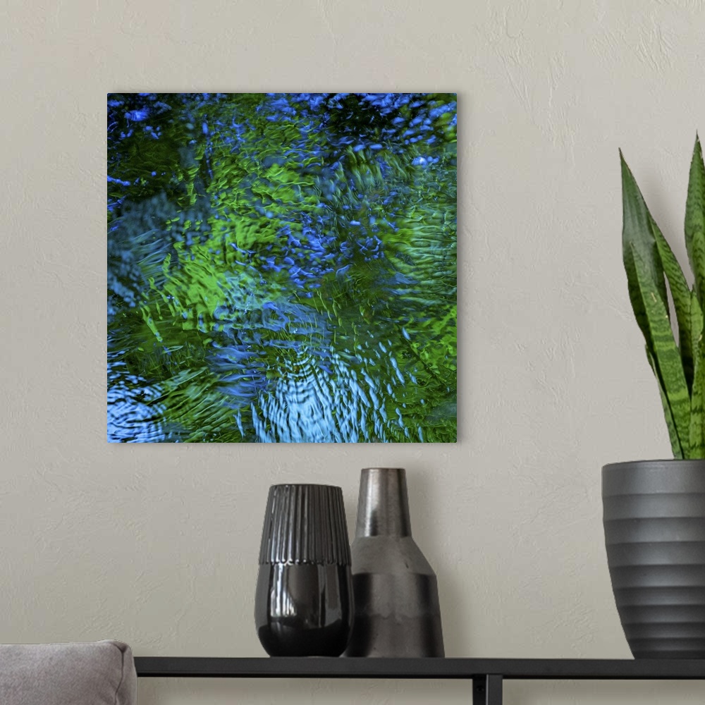 A modern room featuring Blue and green light reflecting in rippling water.