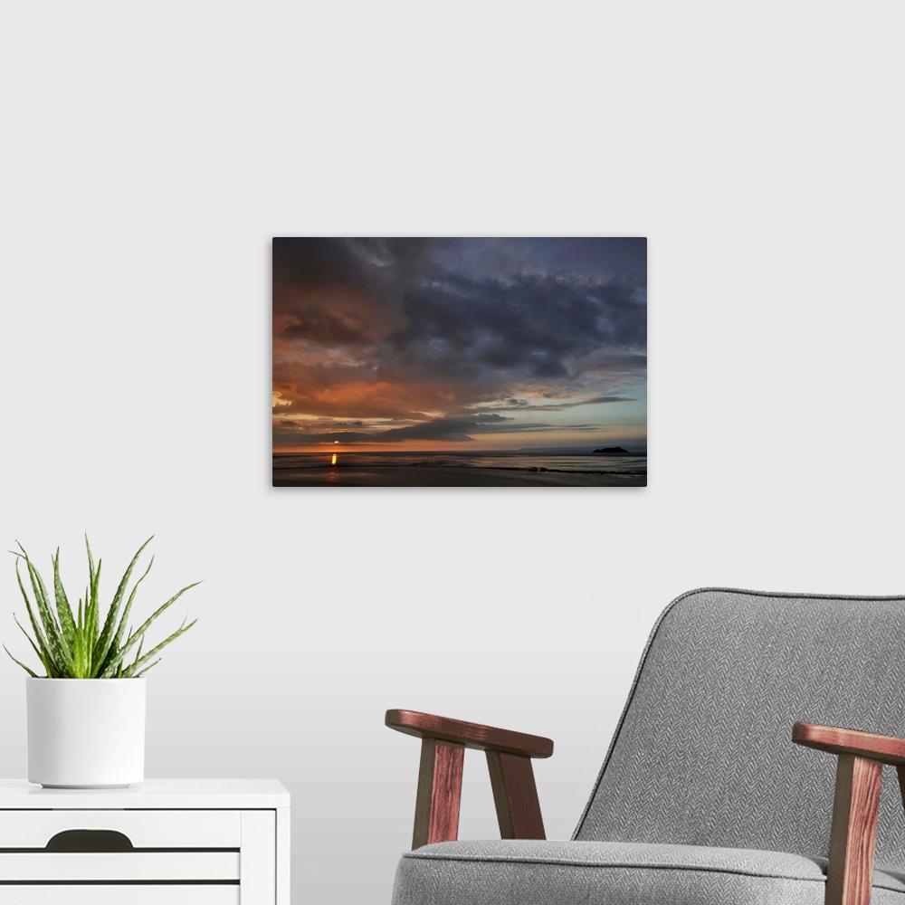 A modern room featuring The large bay of Mont Saint Michel area at the end of the day with big clouds and pink sky.