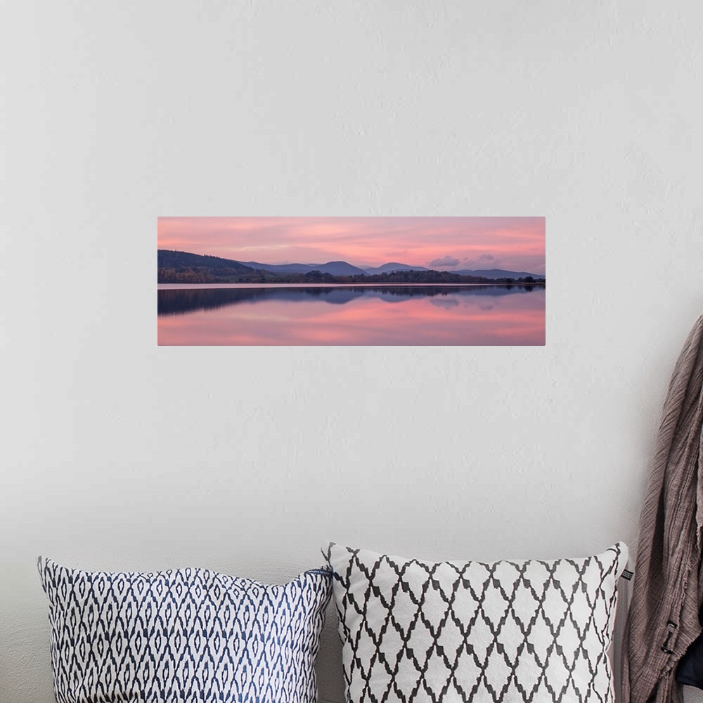 A bohemian room featuring A photograph of a sunrise sky over a countryside landscape.