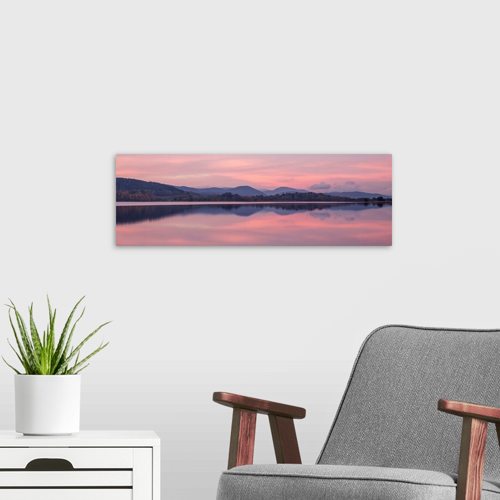 A modern room featuring A photograph of a sunrise sky over a countryside landscape.