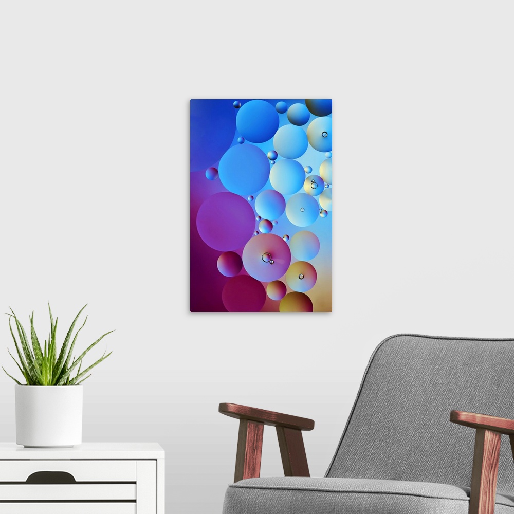 A modern room featuring Circular water drop stacked together with different sizes in shades of blue, pink, purple, and ye...