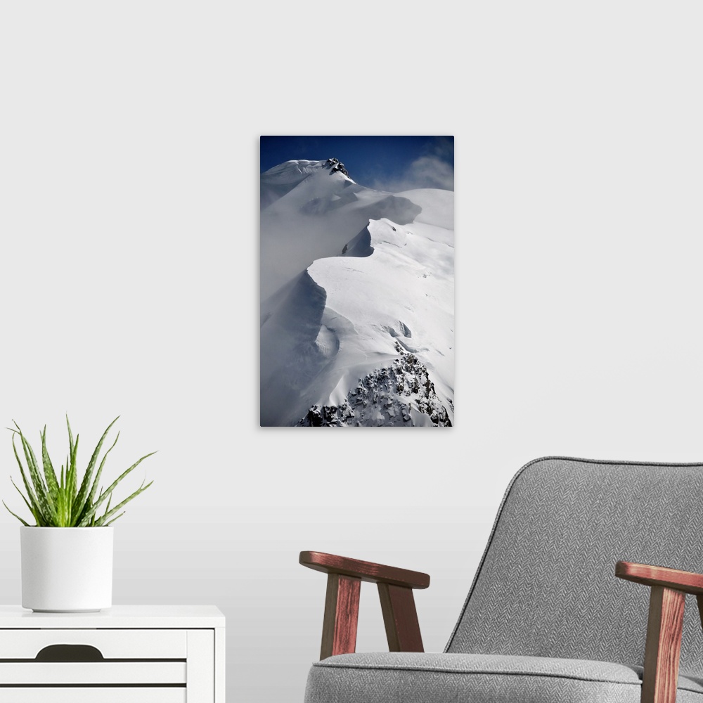 A modern room featuring Mont Blanc du Tacul mountain of the French Alps in France with snow, sun and wind, vertical view.