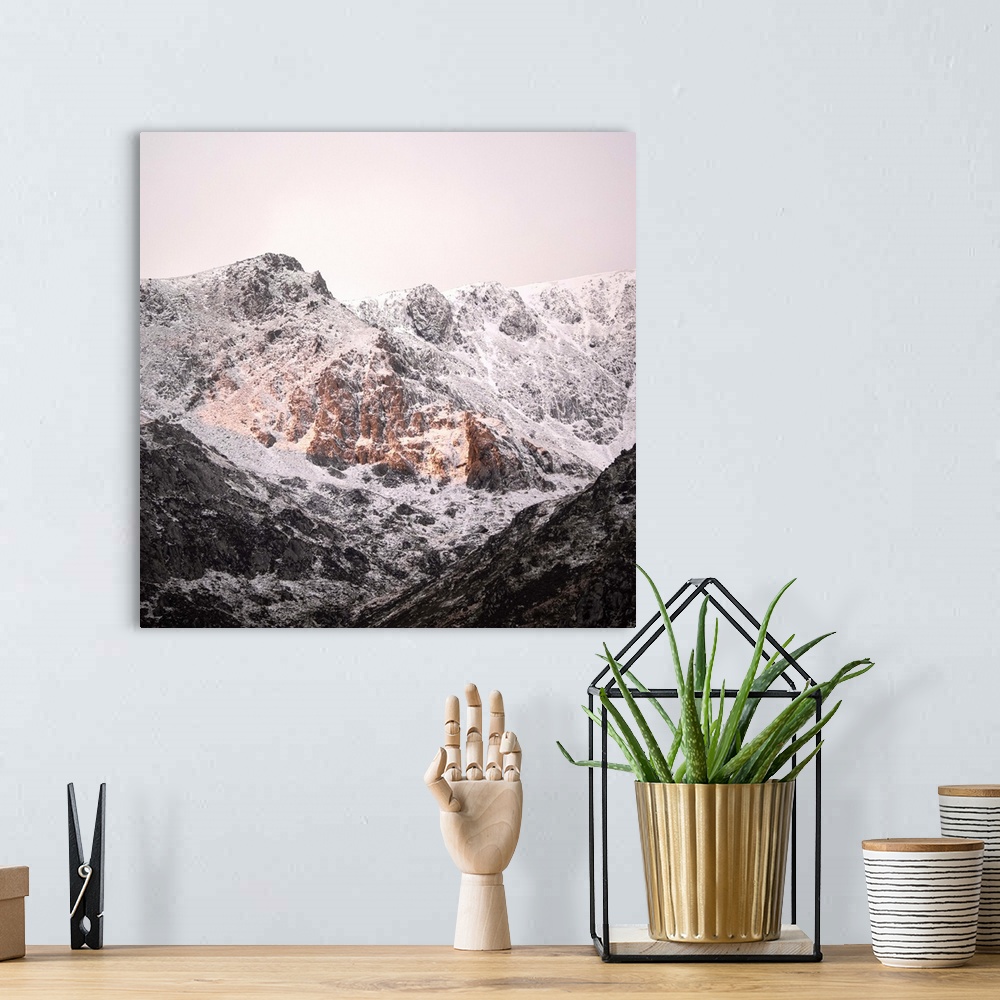 A bohemian room featuring A photograph of a mountain peak covered in snow.