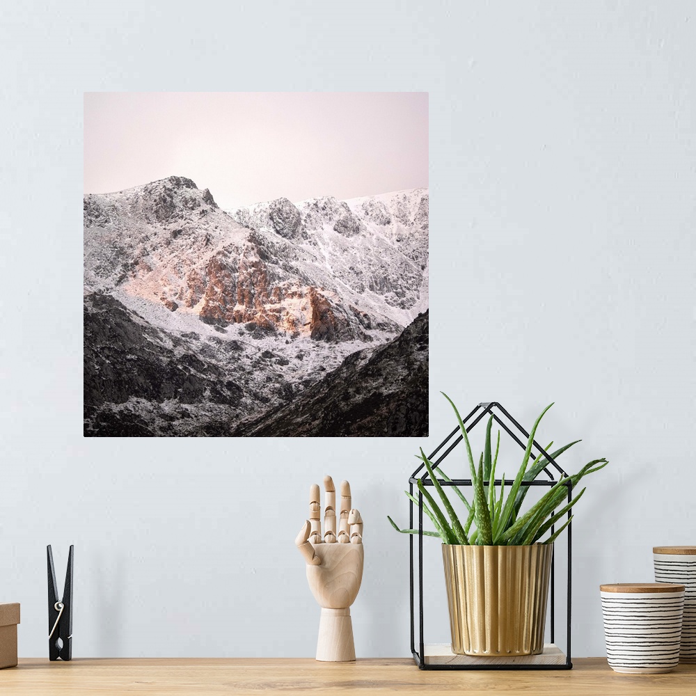 A bohemian room featuring A photograph of a mountain peak covered in snow.