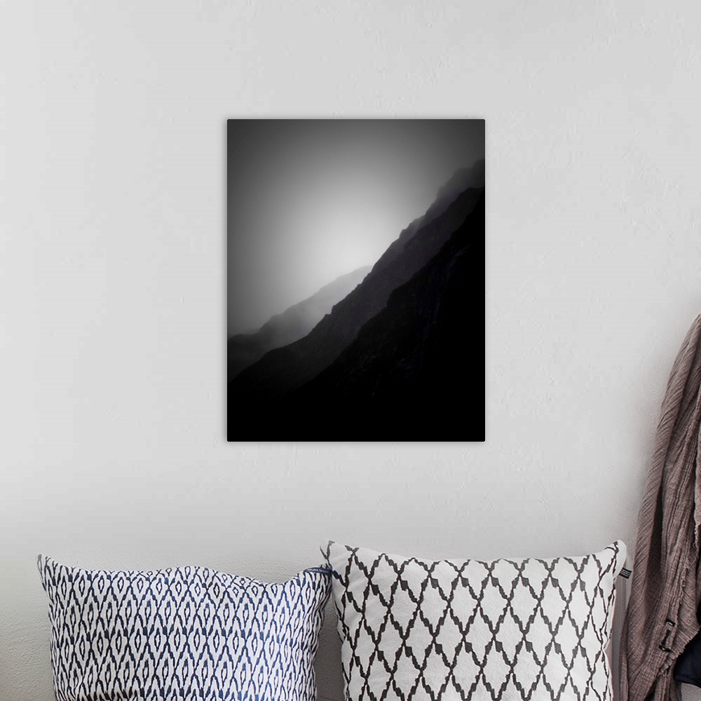 A bohemian room featuring A black and white photograph of silhouetted mountain sides shrouded in haze.