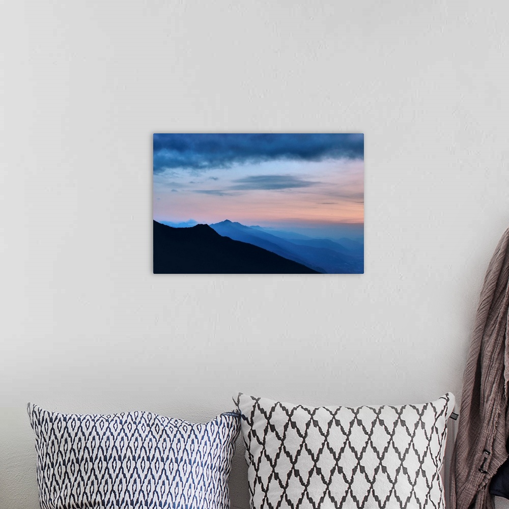 A bohemian room featuring Mountains landscape with infinite horizon at early moning in France with sweet pink clouds above.