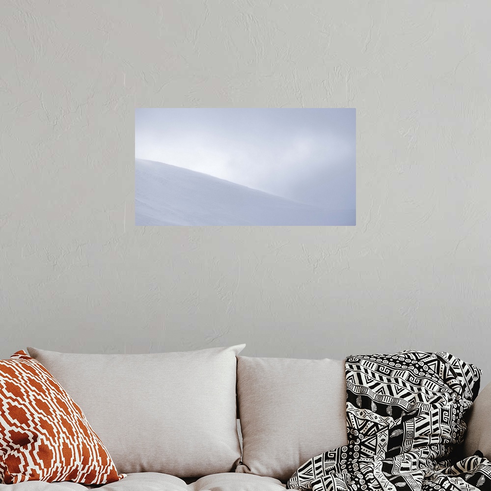 A bohemian room featuring An obscured view of a mountain top covered in snow and surrounded by fog.