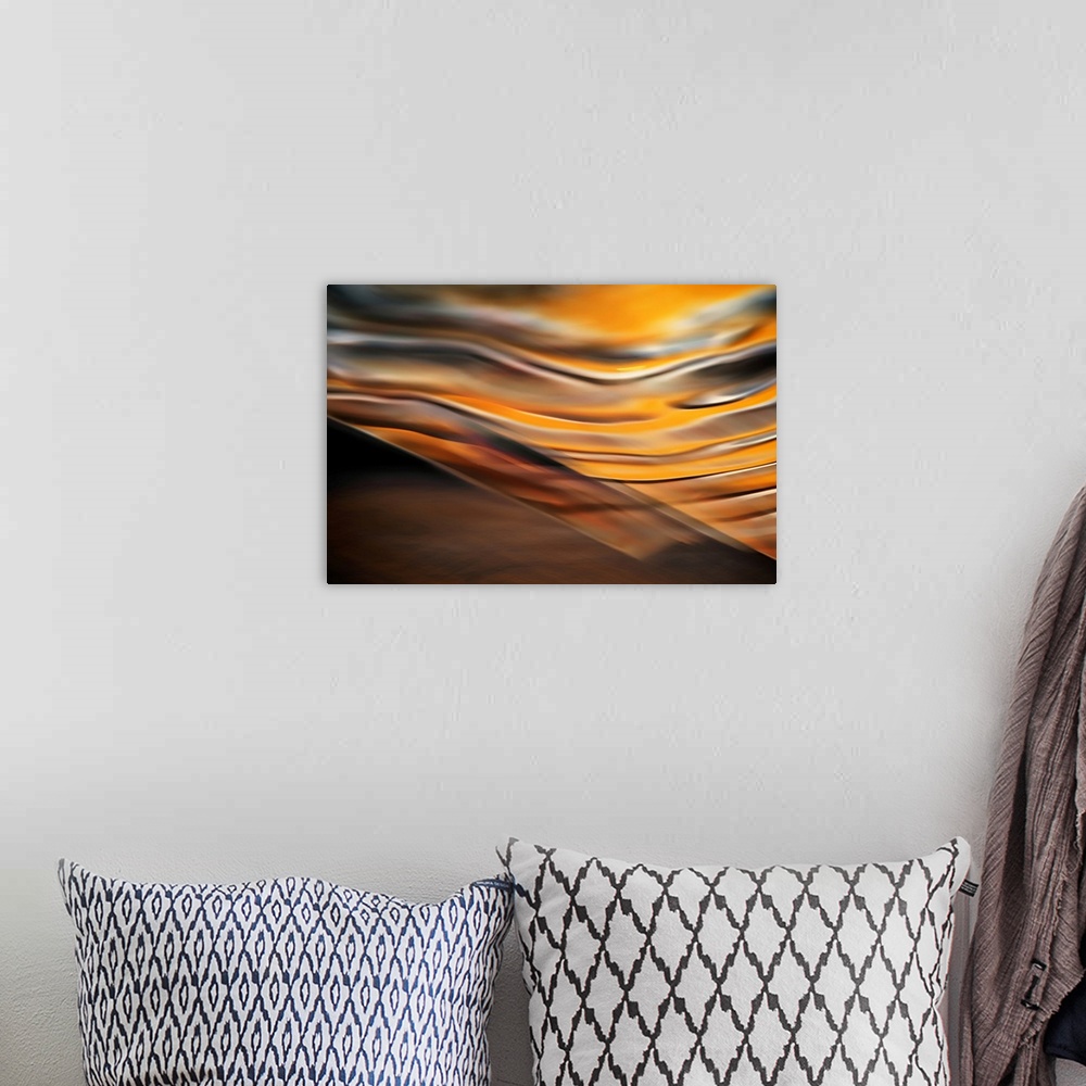 A bohemian room featuring Abstract artwork of flowing earthy colors that have been blended to create subtle ripples above a...