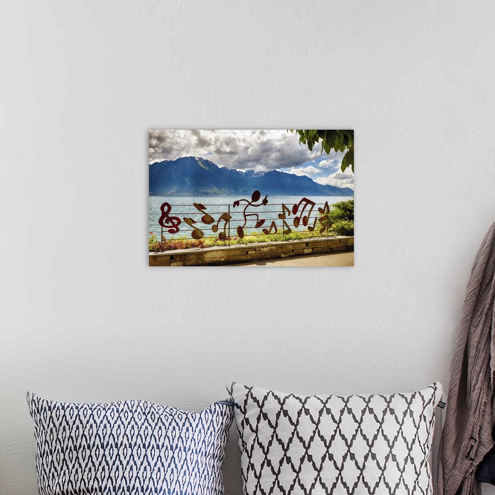 A bohemian room featuring A photograph of a mountain range in the distance from musical notation decorated fence.