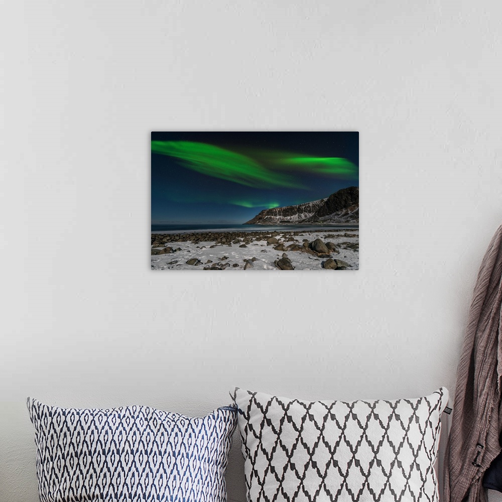 A bohemian room featuring A photograph of the northern lights over a snowy rugged landscape with mountains in the distance.