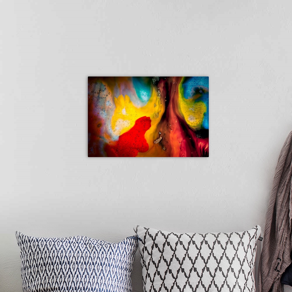 A bohemian room featuring Fine art abstract photograph of swirling paint in bright reds and yellows.