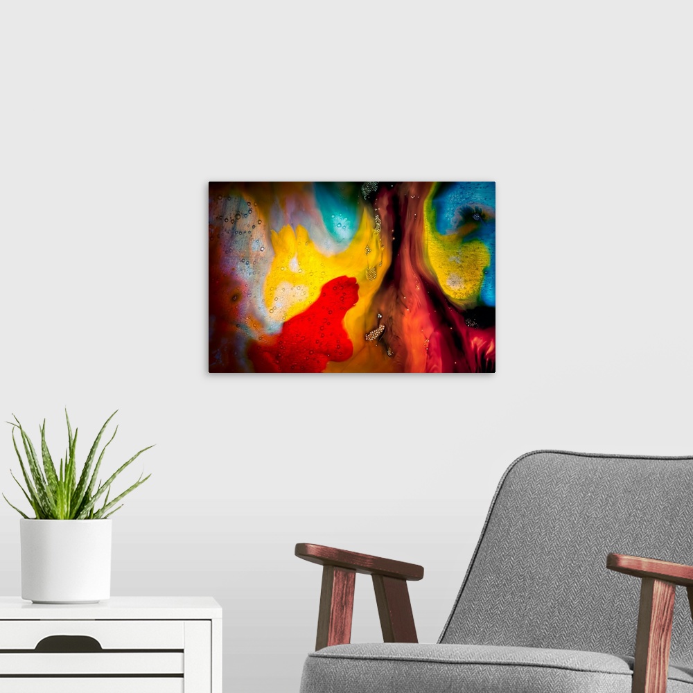 A modern room featuring Fine art abstract photograph of swirling paint in bright reds and yellows.