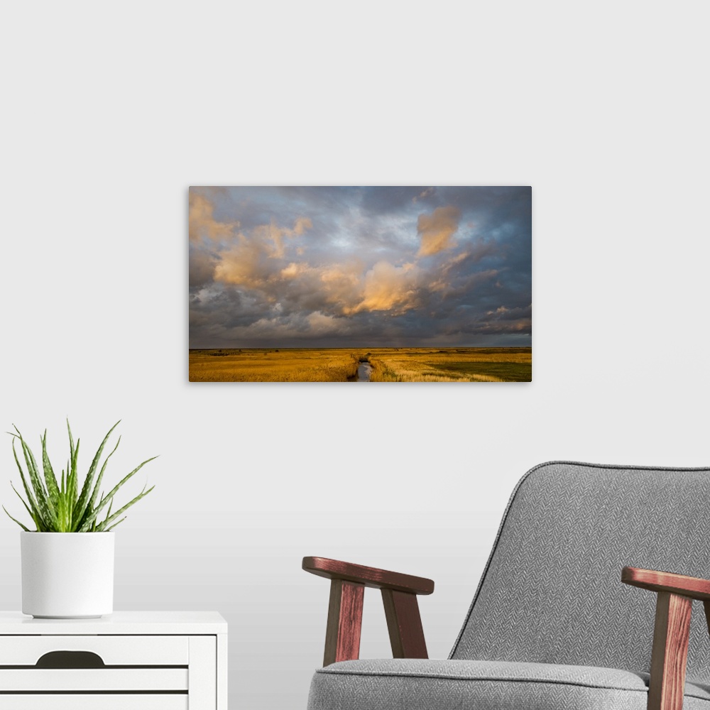 A modern room featuring Photograph of a beautiful skyscape in Norfolk, England, with a stream in the center moving toward...