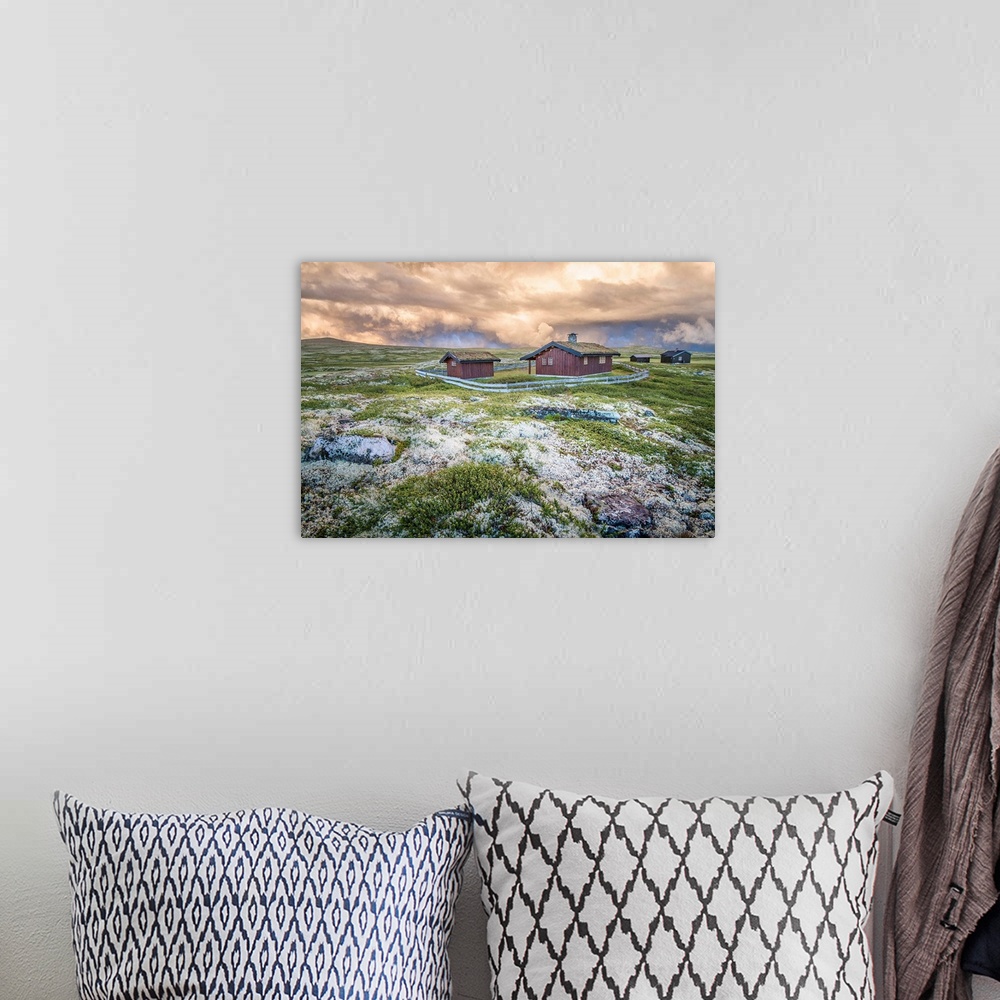 A bohemian room featuring A photograph of a Norwegian landscape with post storm clouds hanging overhead.