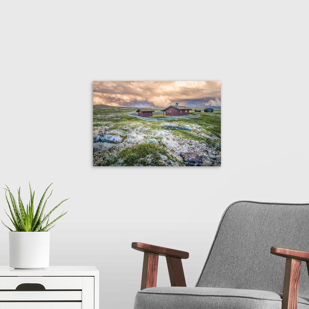 A modern room featuring A photograph of a Norwegian landscape with post storm clouds hanging overhead.