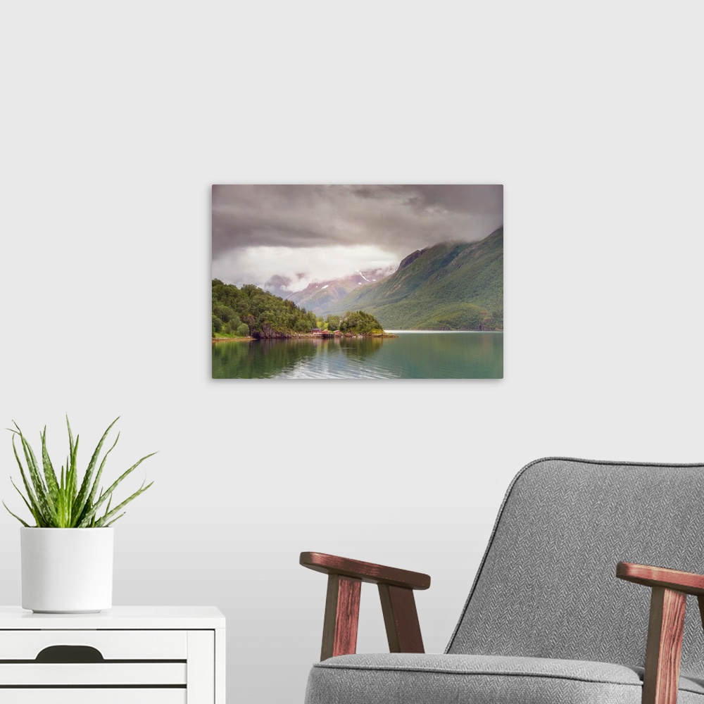 A modern room featuring A Norwegian mountain valley under dark dramatic clouds.