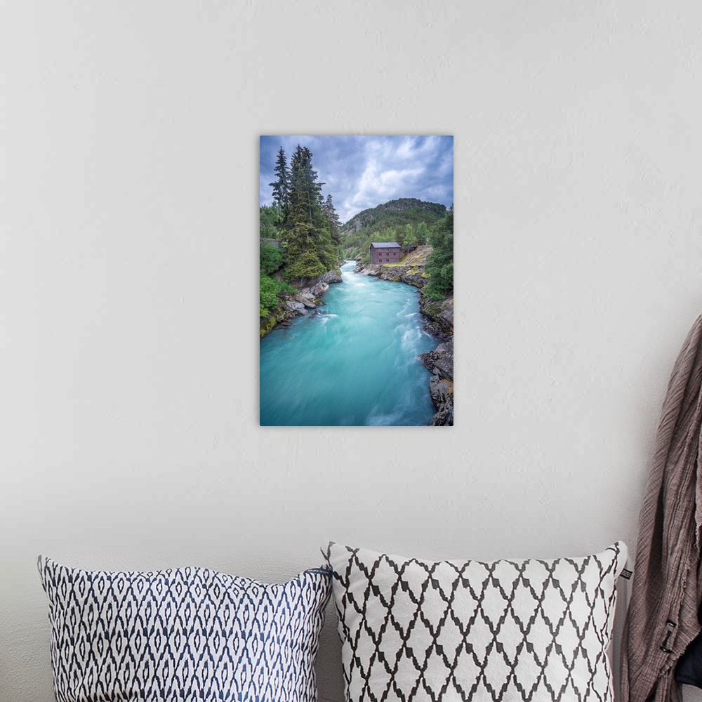 A bohemian room featuring A photograph of a crystal blue river flowing through a Norwegian landscape.