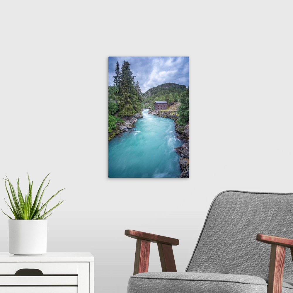 A modern room featuring A photograph of a crystal blue river flowing through a Norwegian landscape.