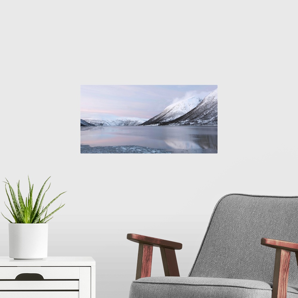 A modern room featuring A tranquil cool pink blue mountainscape dawn in the Norweigian snow by a lake.