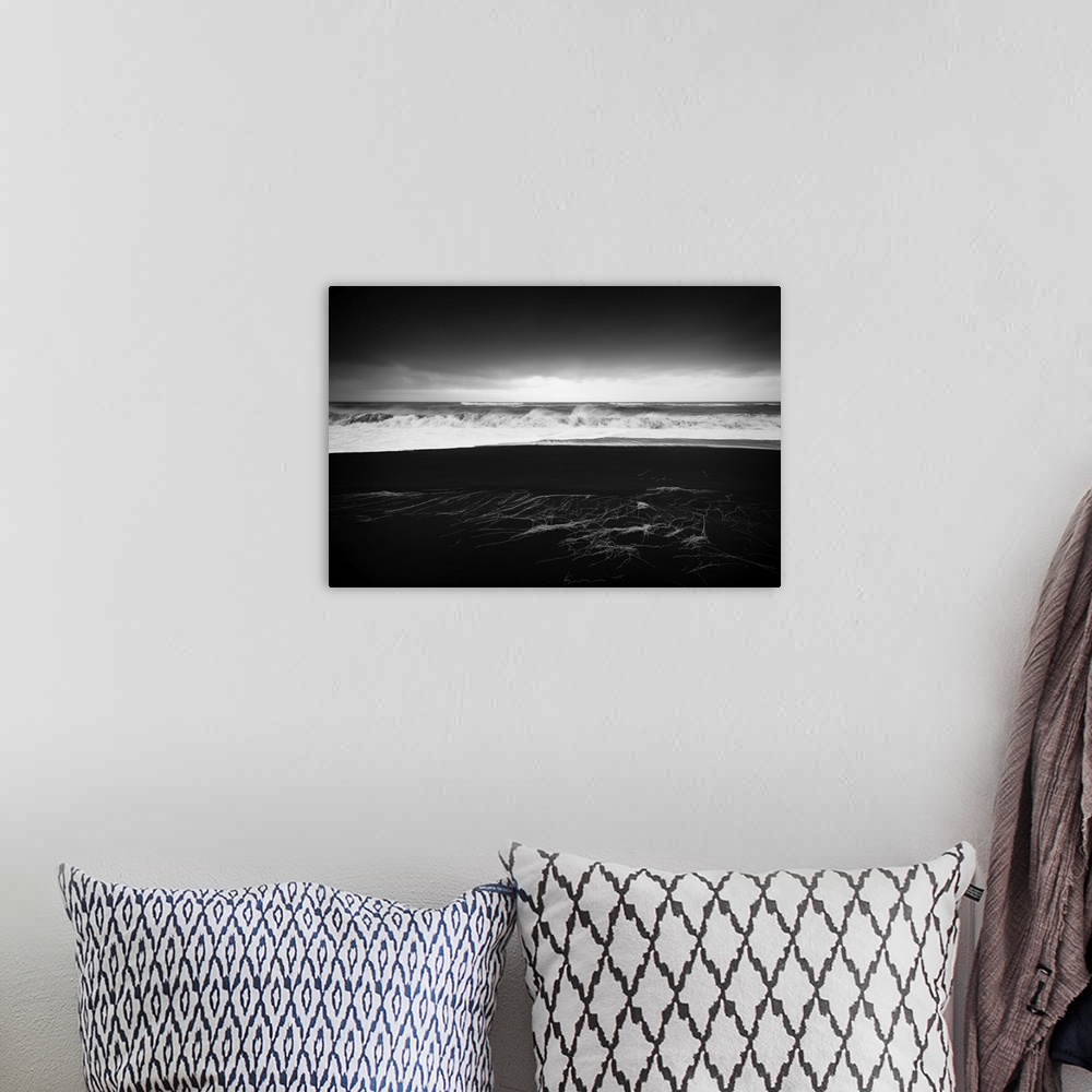 A bohemian room featuring A photograph of a dark coastline under a dark sky.