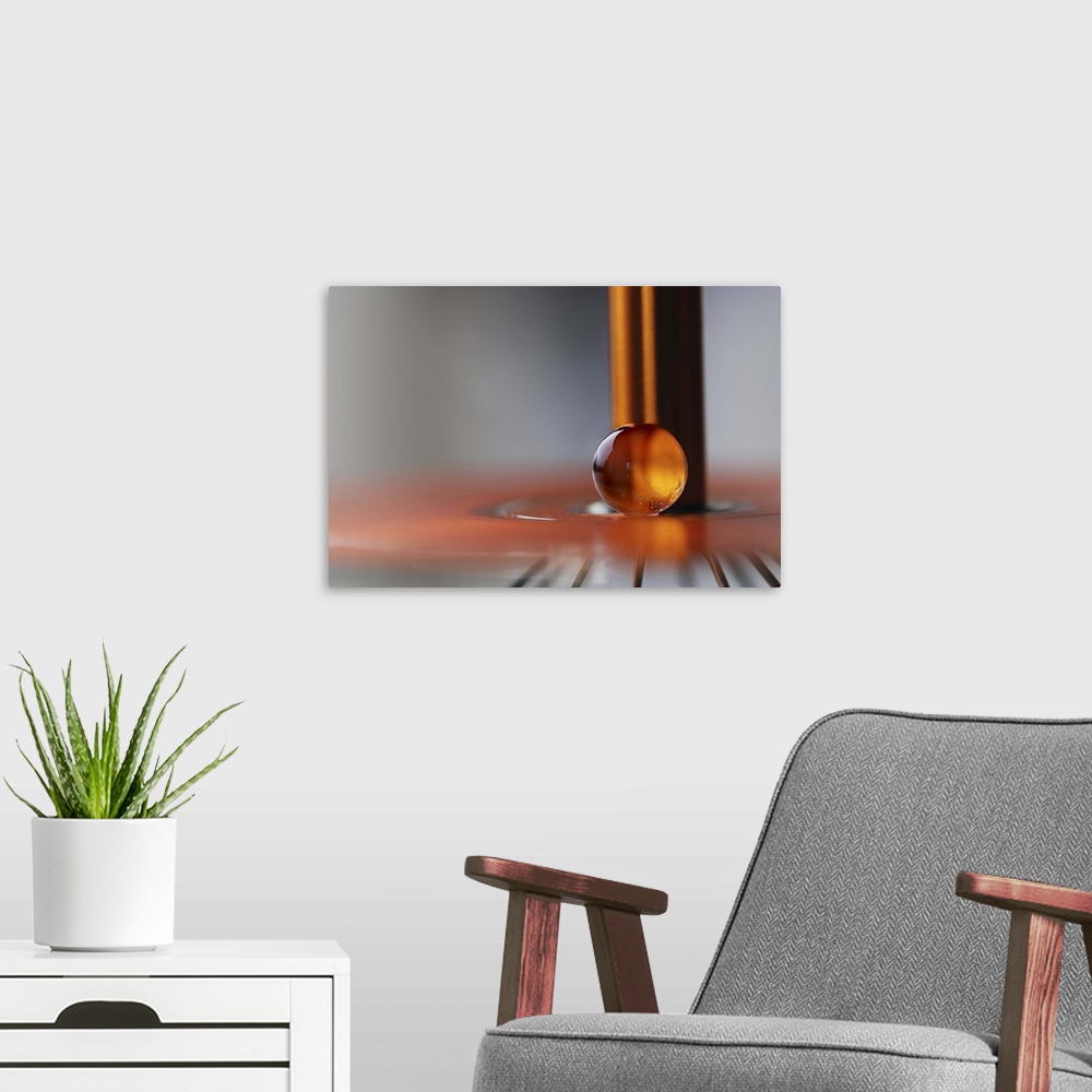A modern room featuring A macro photograph of an orange water droplet against a abstract background.