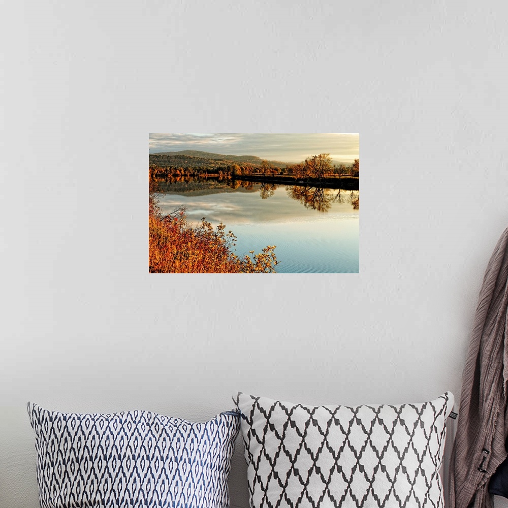 A bohemian room featuring Fine art photo of a calm lake at dusk with an autumn forest in the distance.
