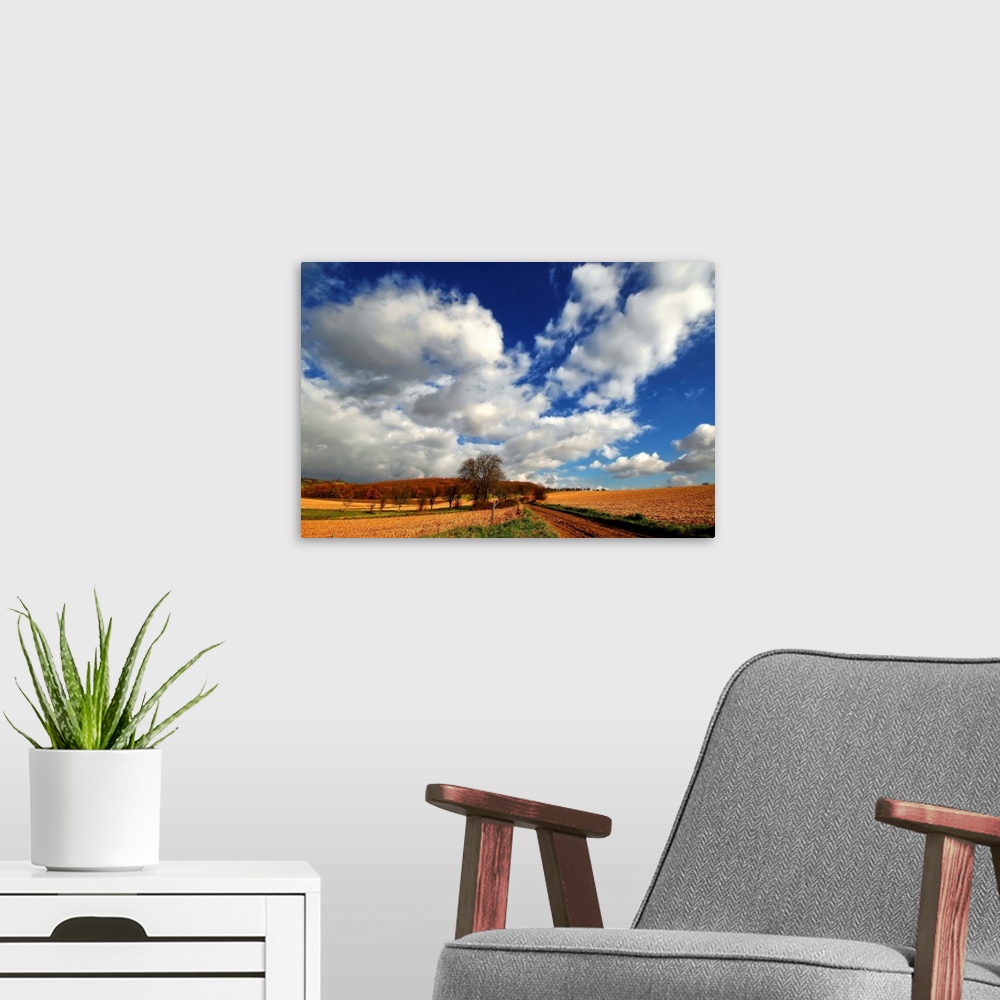 A modern room featuring Blue sky with heavy clouds above the countryside