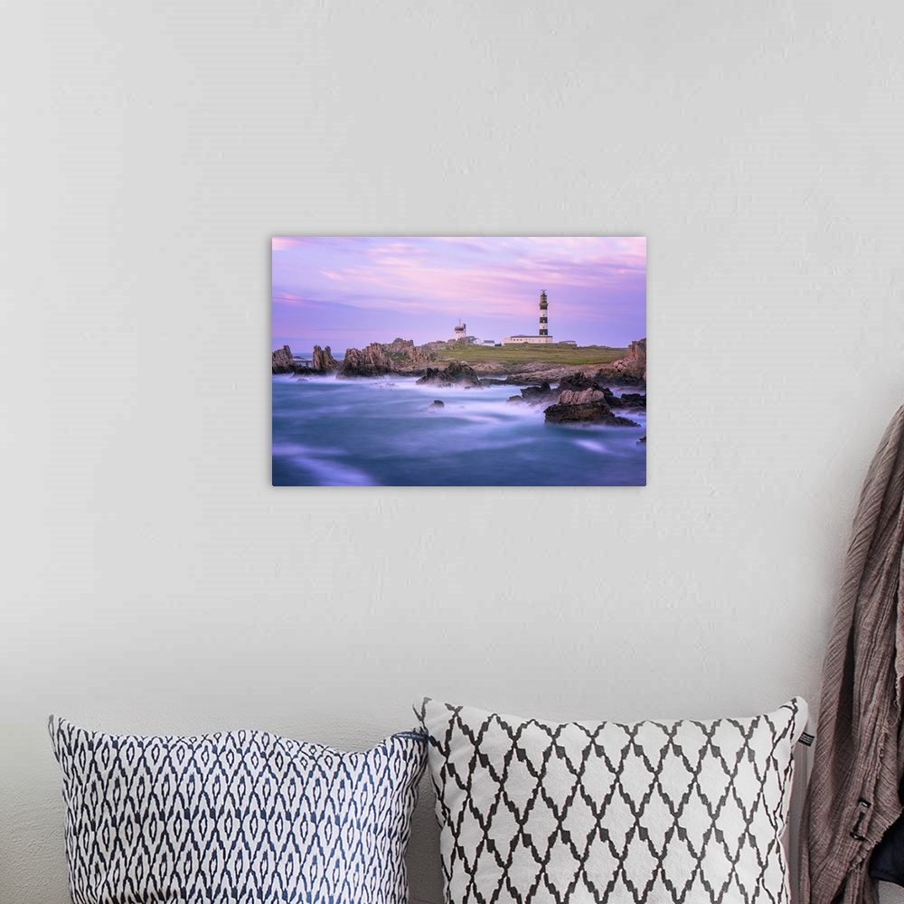 A bohemian room featuring A coastal landscape with a striped lighthouse in the distance.