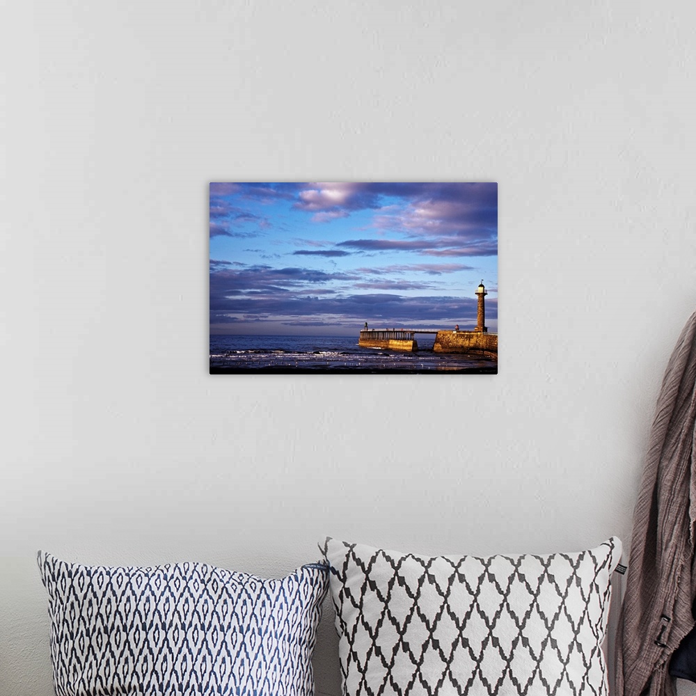 A bohemian room featuring Photograph taken overlooking the ocean with a small pier and lighthouse pictured just to the right.