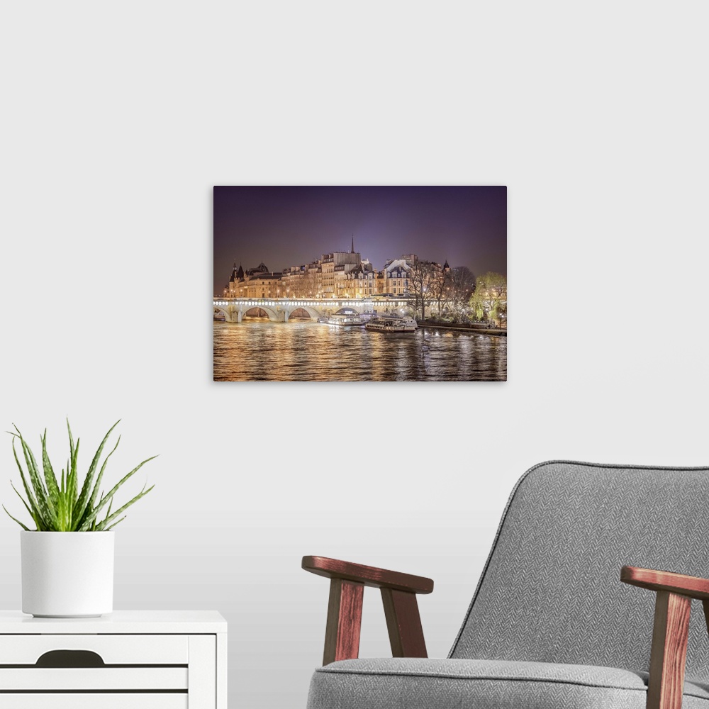 A modern room featuring A photograph of Paris from the Seine river at night.